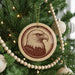 A Christmas tree decorated with ornaments, including a circular ornament featuring a close-up of an eagle's head.