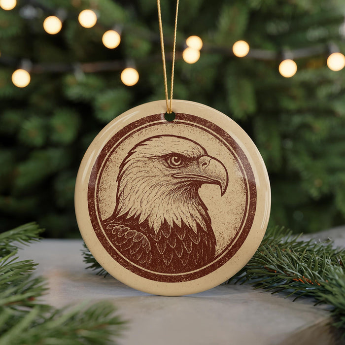 A circular ornament featuring a detailed illustration of an eagle is displayed in front of a blurred background of Christmas lights.