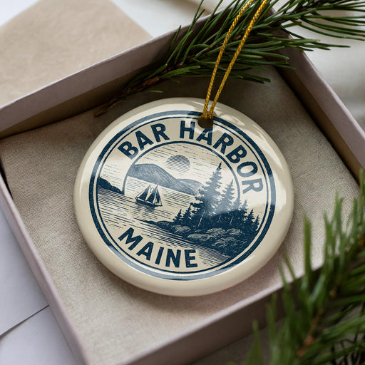 A circular ornament with the text "BAR HARBOR MAINE" printed on it, surrounded by a pine branch and pine needles.
