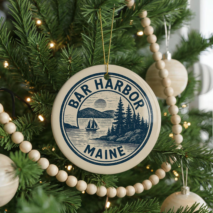 A Christmas tree decorated with ornaments, including a circular ornament with the text "BAR HARBOR Maine" and a sailboat illustration.