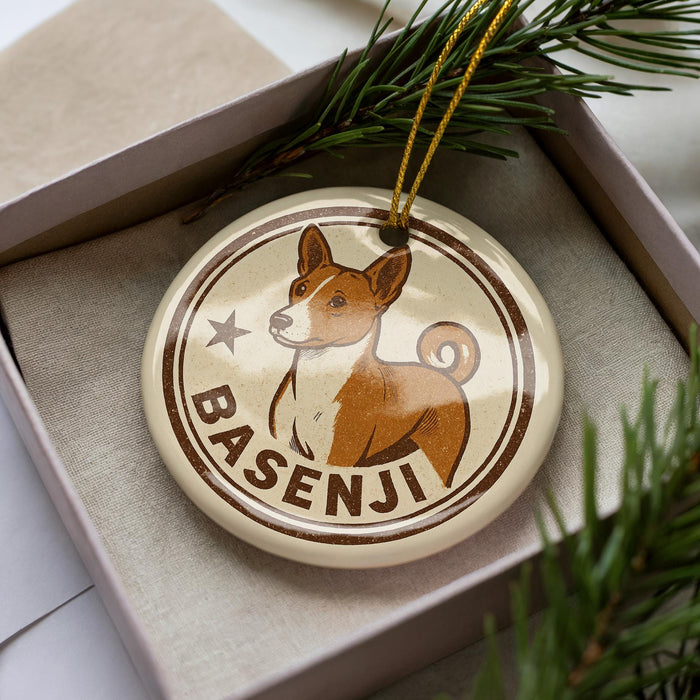 A circular ornament featuring a brown dog with a white belly, surrounded by a star and the word "BASENJI" written on it.