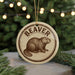 A circular ornament featuring a beaver illustration, with the word "BEAVER" written around the edge.