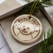 A circular ornament with a dog's face and the text "BICHON FRISE" is displayed in a box, surrounded by pine branches.