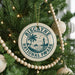 A Christmas tree decorated with ornaments, including a circular ornament with the text "Biscayne National Pap Park" and a lighthouse image.
