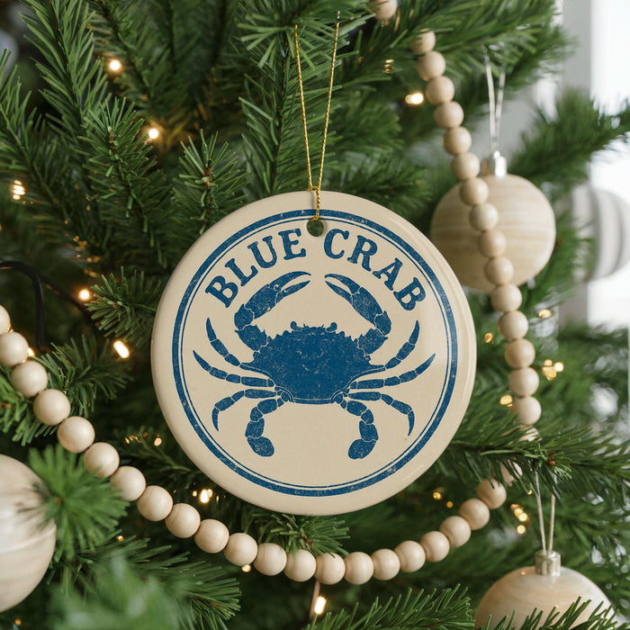 A Christmas tree decorated with ornaments, including a blue crab ornament with the text "BLUE CRAB" on it.