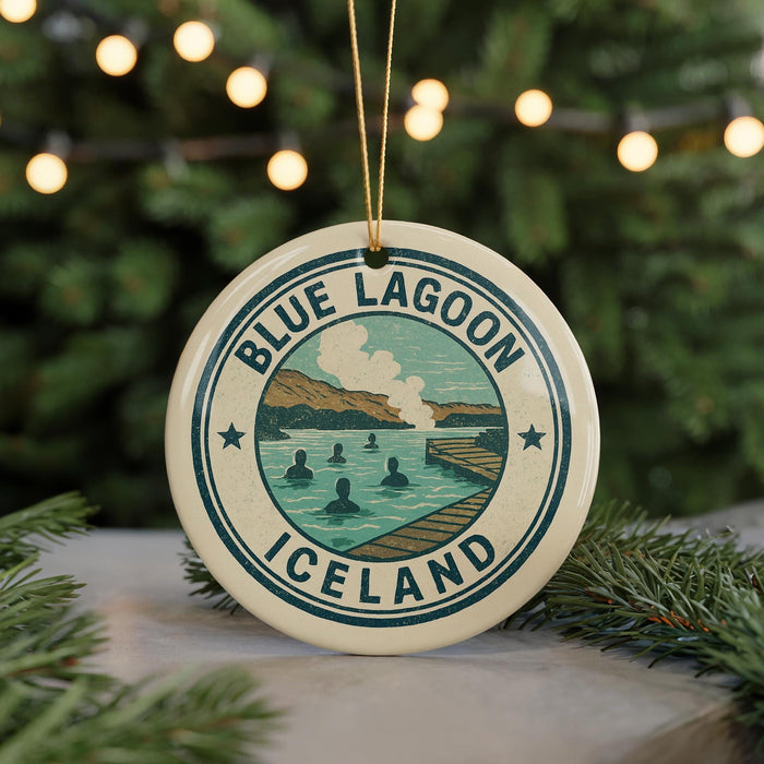A circular ornament with the text "BLUE LAGOON ICELAND" and an illustration of a scenic landscape with people swimming in a lake.