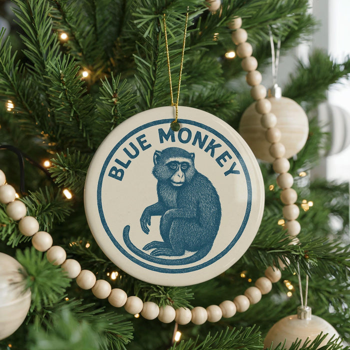 A Christmas tree decorated with ornaments, including a blue and white ornament featuring a monkey.
