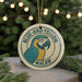 A circular ornament with a parrot design, featuring the text "BLUE-AND-YELLOW MACAW" around the edge.