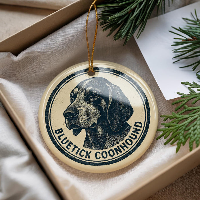 A circular ornament featuring a black and white illustration of a blue heeler coonhound dog, with the text "BLUETICK COONHOUND" printed on it.