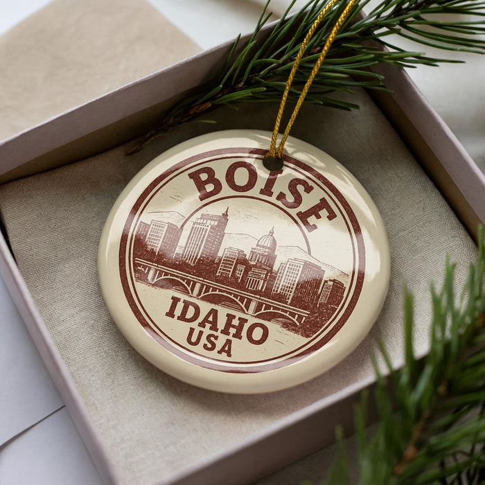 A circular ornament with the text "BOISE IDAHO USA" printed on it, surrounded by pine branches.