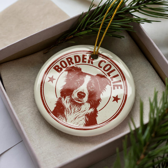 A white ceramic ornament with a red border and a picture of a Border Collie dog.