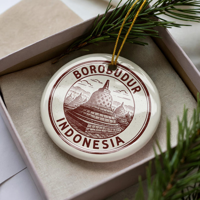 A circular ornament with the text "BOROBUDUR INDONESIA" printed on it, surrounded by pine branches.