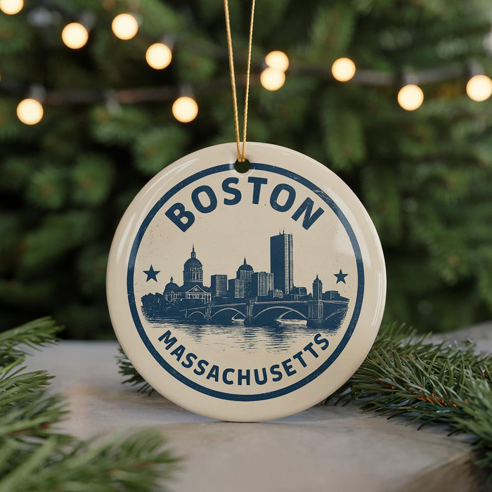 A circular ornament with the text "BOSTON MASSACHUSETTS" and a graphic of the Boston skyline, hanging from a string.