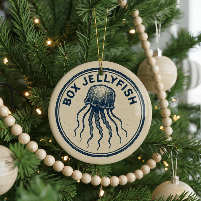 A Christmas tree decorated with ornaments, including a round ornament with a blue jellyfish design and the text "BOX JELLYFISH" on it.