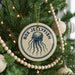 A Christmas tree decorated with ornaments, including a round ornament with a blue jellyfish design and the text "BOX JELLYFISH" on it.