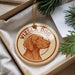 A round ornament with a brown dog image and the text "Vizsla Dog" is displayed in a box with pine branches.