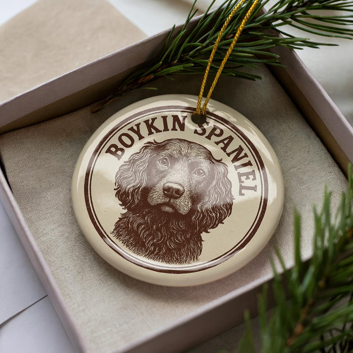 A circular ornament featuring a brown and white image of a Boykin Spaniel dog, with the text "BOYKIN SPANIEL" printed on it.
