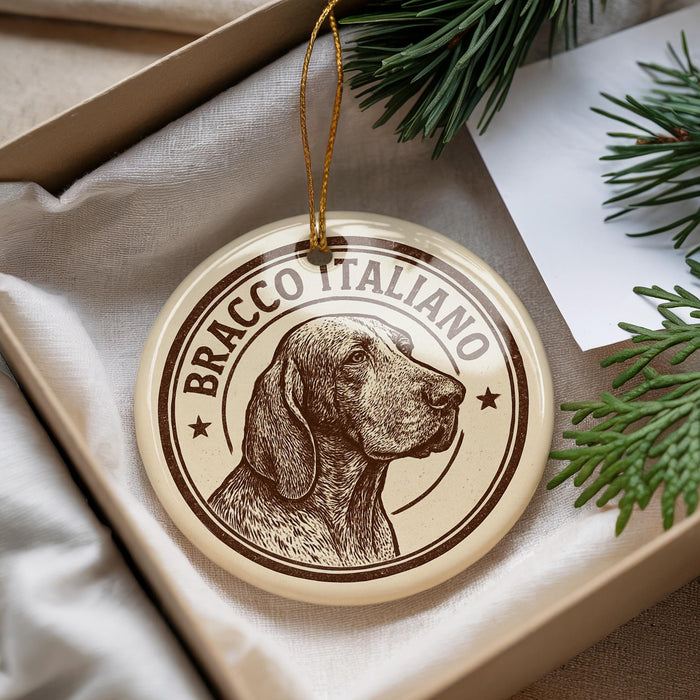 A round ornament with a dog's head and the text "BRACCO ITALIANO" printed on it, hanging from a string.