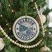 A Christmas tree decorated with ornaments, including a circular ornament with the text "BRANSON MISSOURI" and a boat illustration.