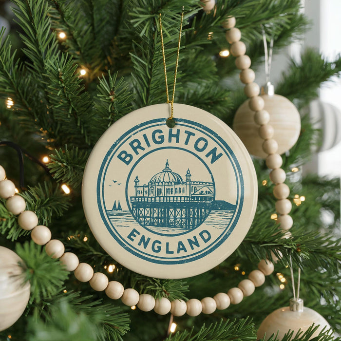 A Christmas tree decorated with ornaments, including a circular ornament with the text "BRIGHTON ENGLAND" and a drawing of a building.