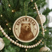 A Christmas tree decorated with ornaments, including a circular ornament with a brown bear image and the text "Brown Bear".