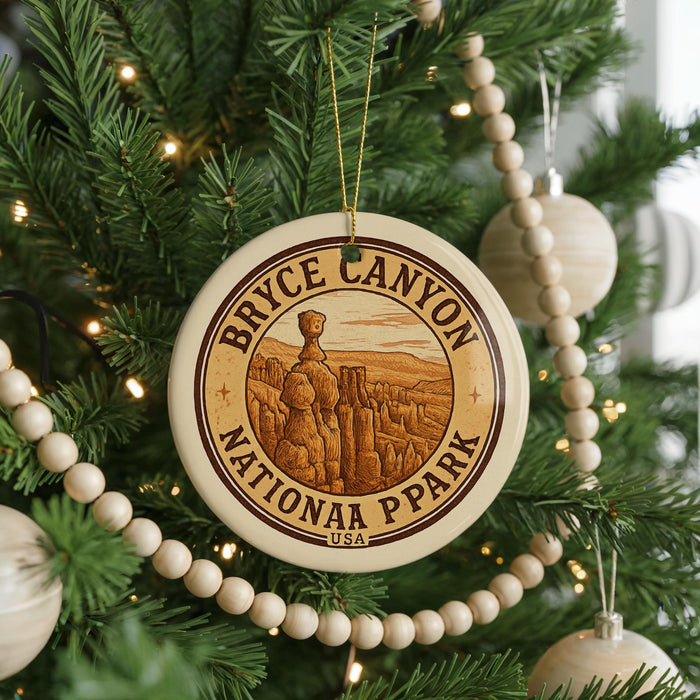 A circular ornament on a Christmas tree, featuring the text "BRYCE CANYON NATIONAL PARK USA" and an illustration of a mountain range.