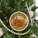 A circular ornament on a Christmas tree, featuring the text "BRYCE CANYON NATIONAL PARK USA" and an illustration of a mountain range.