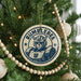 A circular ornament on a Christmas tree featuring a Bumblebee character from the Transformers franchise.