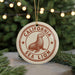 A round ornament with the text "CALIFORNIA SEA LION" and a seal illustration, hanging from a string.