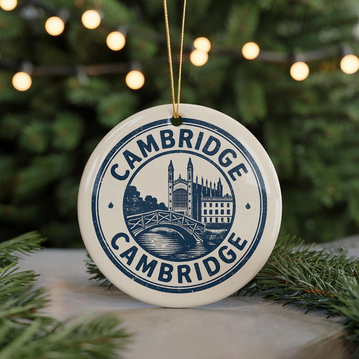 A white ceramic ornament with the text "CAMBRIDGE" and an illustration of a castle or palace, hanging from a string.