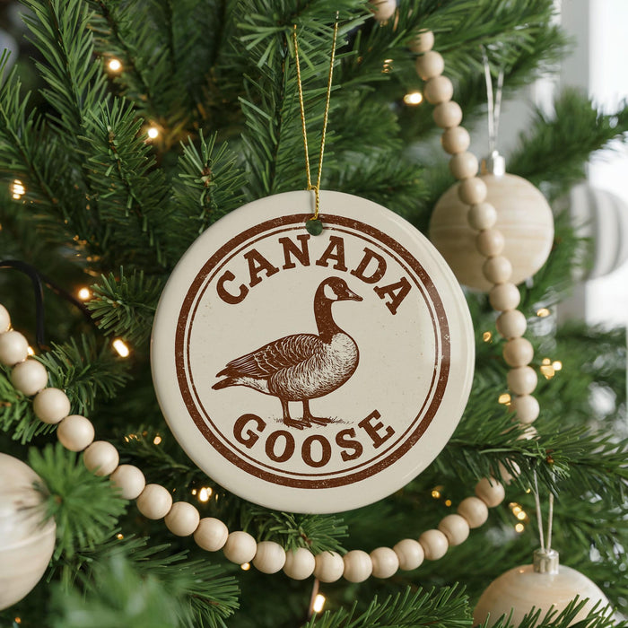 A Christmas tree decorated with ornaments, including a circular ornament with a goose and the text "CANADA GOOSE" on it.