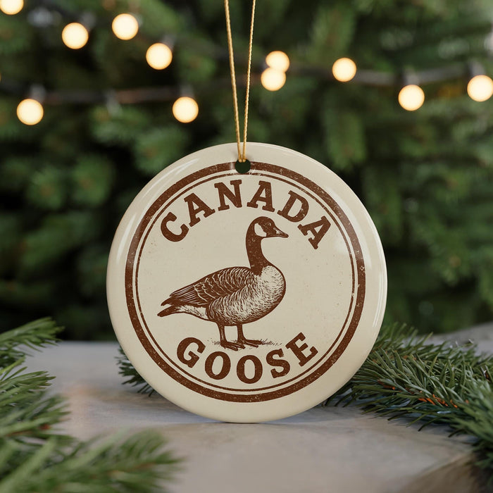 A circular ornament with the text "CANADA GOOSE" and a graphic of a goose is displayed in front of a Christmas tree with twinkling lights.