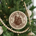 A Christmas tree decorated with ornaments, including a large circular ornament with a picture of a dog's head and the text "CANE CORSO" around it.
