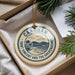 A circular ornament with the text "CANOUAN SAINT VINCENT AND THE GREEMANDINES" printed on it, hanging from a string.