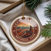 A decorative ornament with the text "CANYONLANDS NATIONAL PARK" and an illustration of a desert landscape with mountains, hanging from a string.