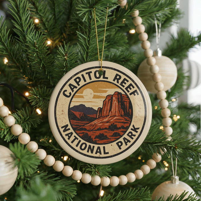 A circular ornament on a Christmas tree, featuring the text "CAPITOL REEF NATIONAL PARK" and an illustration of a desert landscape with mountains.