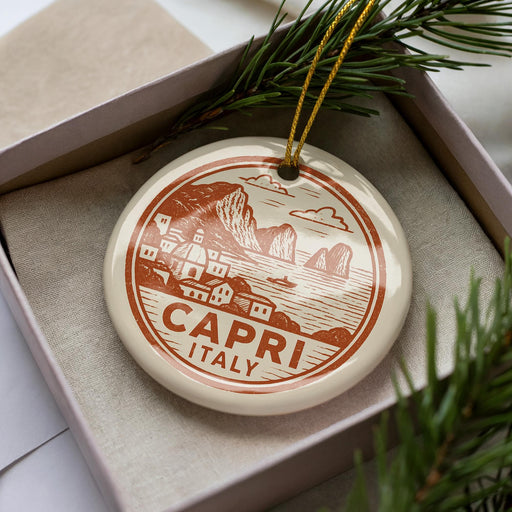 A decorative ornament in a box, featuring a circular design with a coastal scene and the text "CAPRI ITALY".