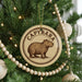 A Christmas tree decorated with ornaments, including a circular ornament with a picture of a capybara and the word "CAPYBARA" written on it.