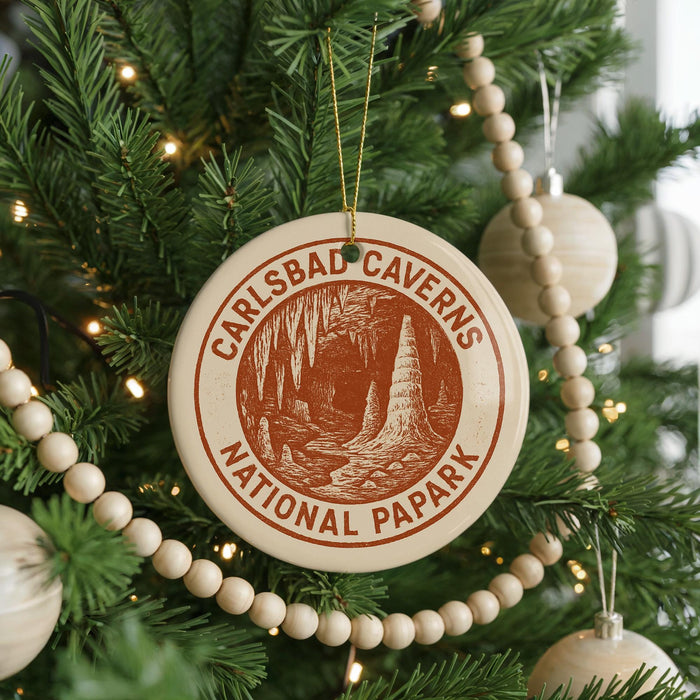 A Christmas tree decorated with ornaments, including a circular ornament with the text "CARLSBAD CAVENS NATIONAL PAPARK" and a beaded ornament.
