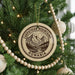 A Christmas tree decorated with ornaments, including a circular ornament with a mountain landscape and the text "CARPATHIAN MOUNTAINS ROMANIA" printed on it.