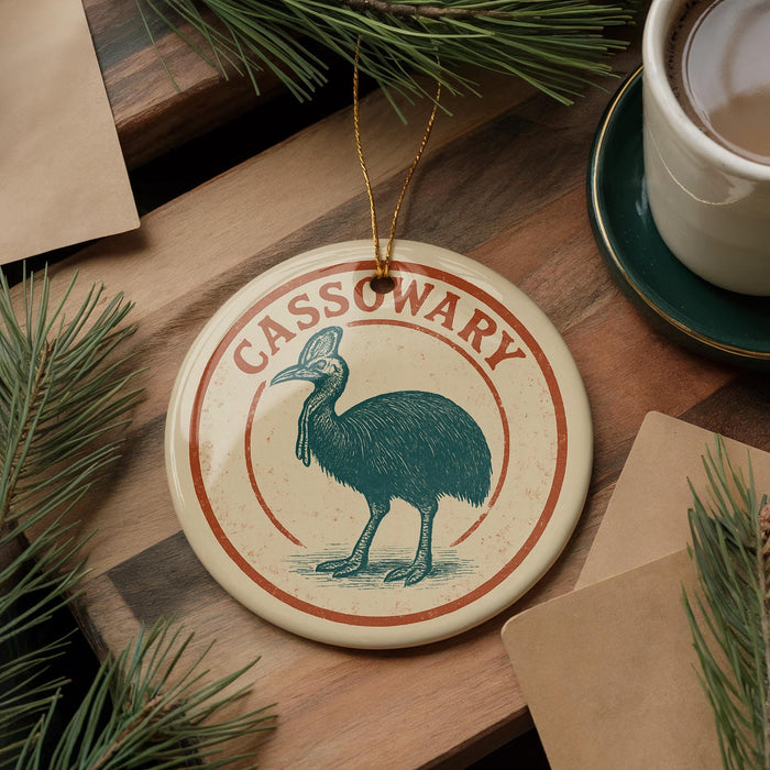 A circular ornament featuring a green bird, possibly a stork, is displayed on a wooden surface alongside a cup of coffee and some pine branches.
