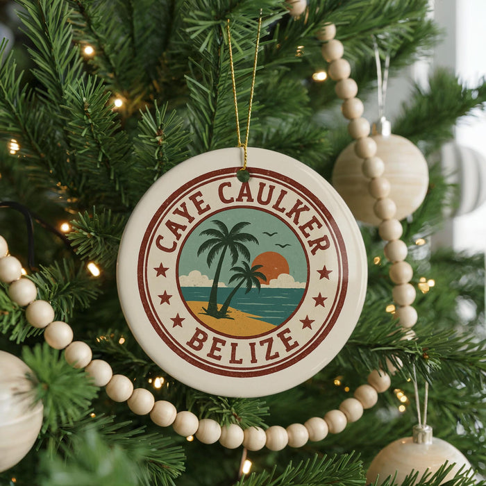 A round ornament on a Christmas tree, featuring a palm tree and beach scene with the text "CAVE CAULKER BELIZE" around the edge.
