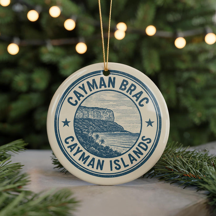 A circular ornament with the text " Cayman Brac Cayman Islands" printed on it, hanging from a string.