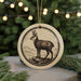 A round ornament featuring a black and white illustration of a mountain goat standing on a rock.
