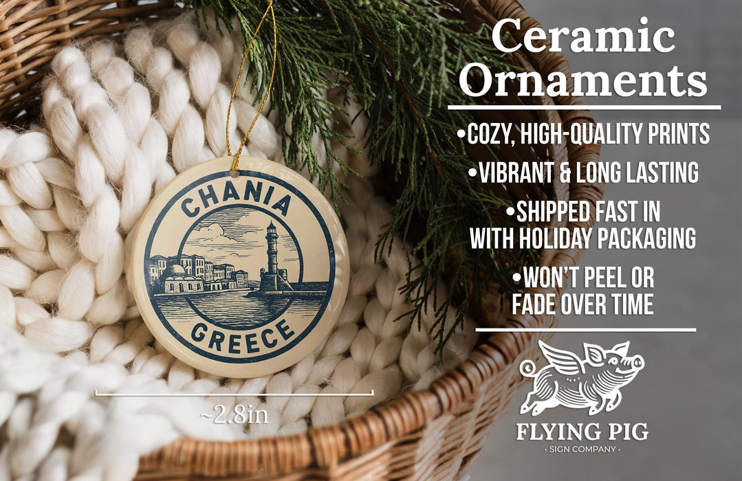 Ceramic ornaments, specifically a round ornament with a lighthouse and chania Greece design, are displayed in a woven basket.