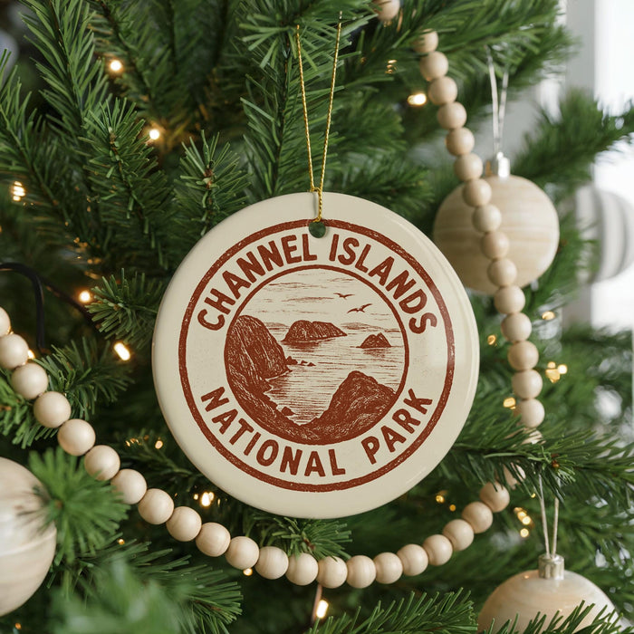 A Christmas tree decorated with ornaments, including a circular ornament with the text "Channel Islands National Park" and a wooden bead decoration.