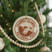 A Christmas tree decorated with ornaments, including a circular ornament with the text "Channel Islands National Park" and a wooden bead decoration.