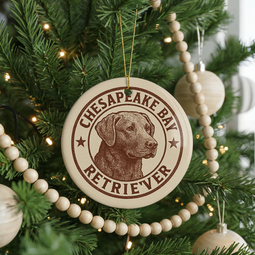 A Christmas tree decorated with ornaments, including a circular ornament with a brown and white design featuring a dog's head and the text "CHESAPKE BAY RETRIEVER".