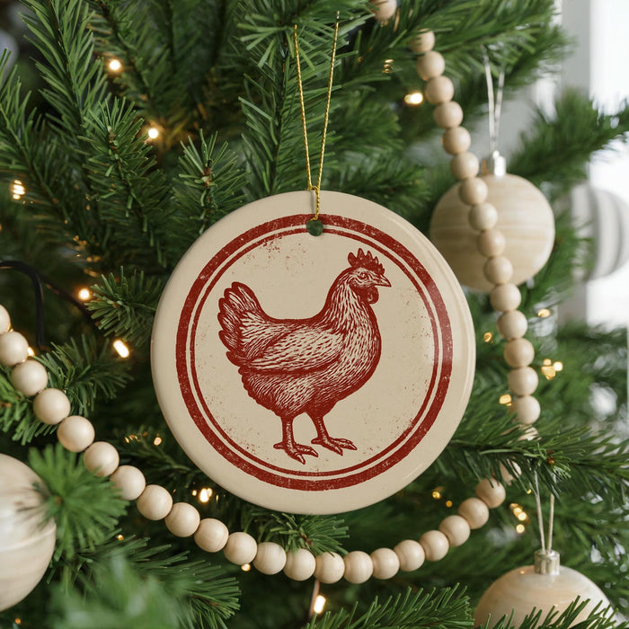 A Christmas tree decorated with ornaments, including a circular ornament featuring a red rooster design.