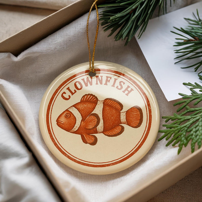 A round ornament with the word "CLOWNFISH" printed on it, featuring an illustration of an orange clownfish.